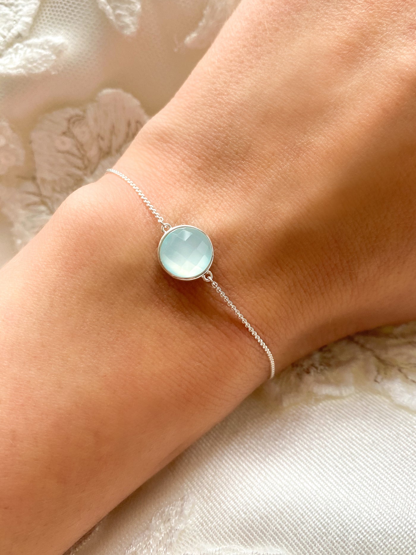  Model wearing silver bridal bracelet with blue aquamarine stone and wedding dress