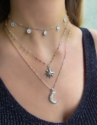 Model wearing sterling silver gold star coin necklace, moon pendant and engraved coin choker with cz crystals