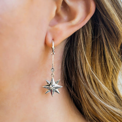 Model wearing statement sterling silver bar star drop hoop earrings with CZ crystals