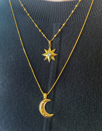 Model wearing gold star necklace, moon pendant