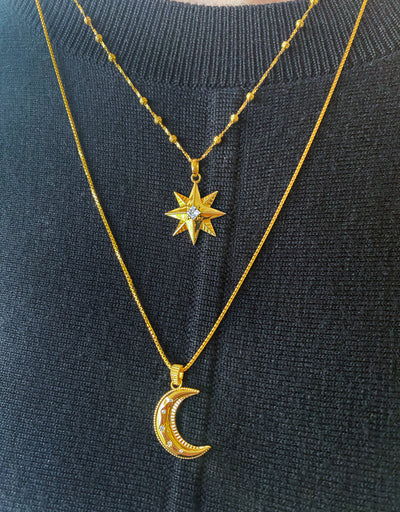 Model wearing gold star coin necklace, moon pendant