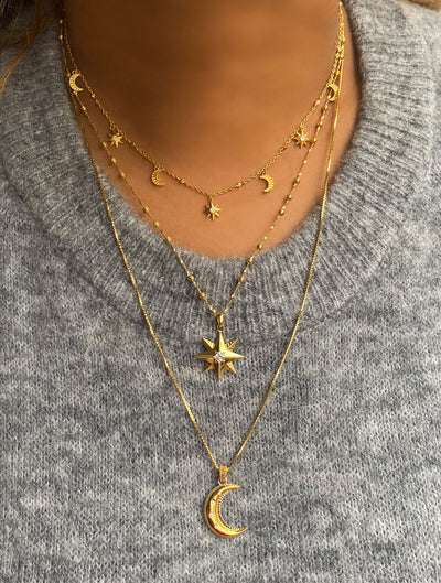 Model wearing gold star necklace, moon pendant and matching choker with CZ crystals