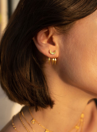 Model wearing gold plated sterling silver engraved moon front back ear jackets with hanging spikes