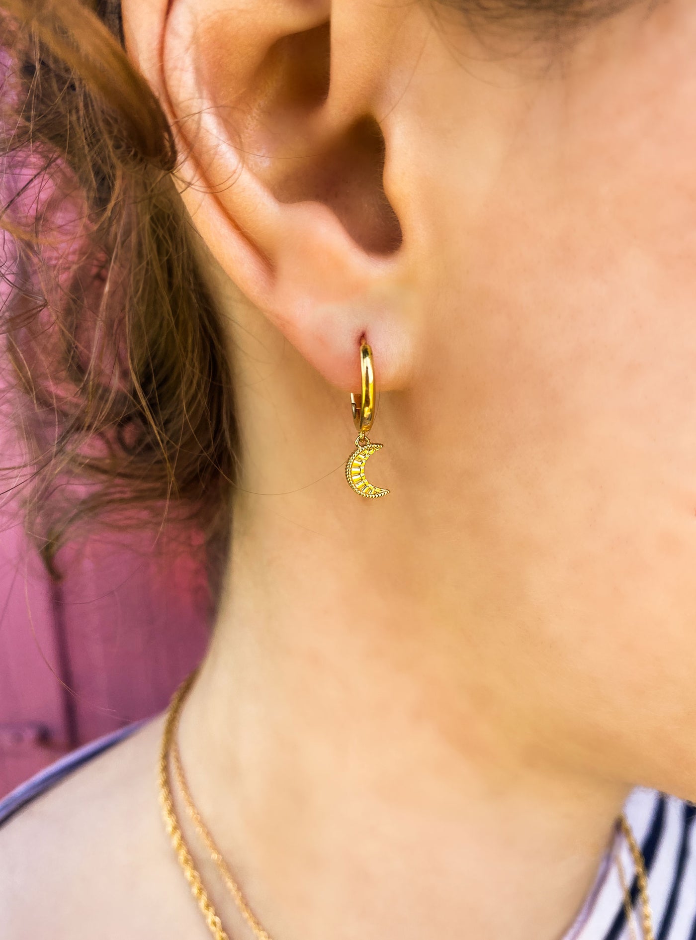 Model wearing mini gold engraved moon huggie hoop