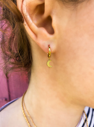 Model wearing mini gold engraved moon huggie hoop