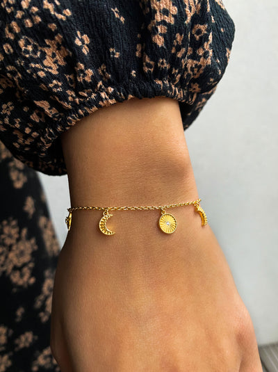 Model wearing gold plated sterling Silver moon and star charm bracelet with CZ crystals