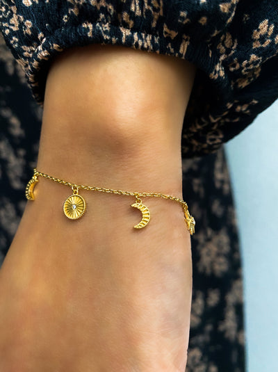Model wearing gold plated sterling Silver moon and star charm bracelet with CZ crystals