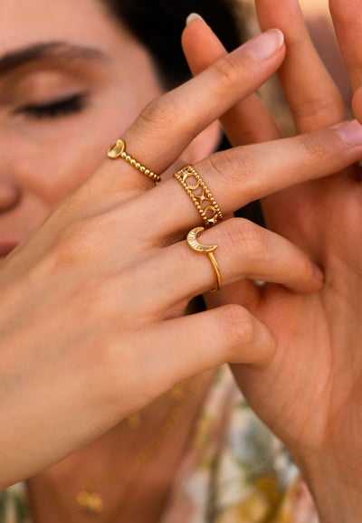 Model wearing gold plated sterling silver moon and star filigree ring with engraved moon and sun ring set 