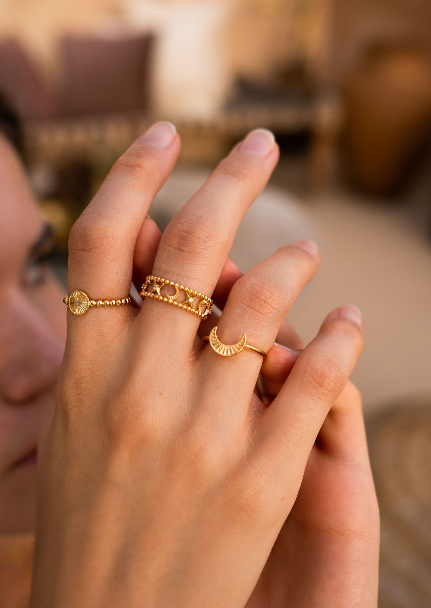 Model wearing gold plated sterling silver moon and star filigree ring with engraved moon and sun ring set 