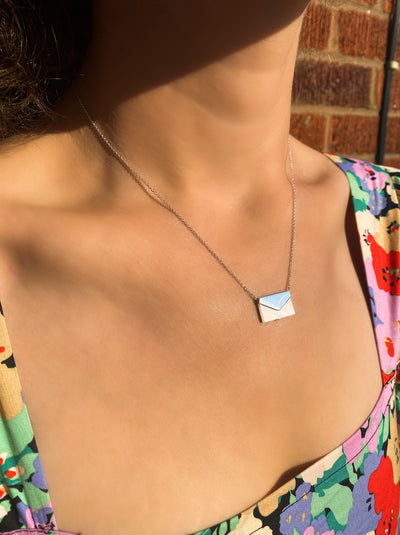 Model wearing silver envelope necklace with moonstone