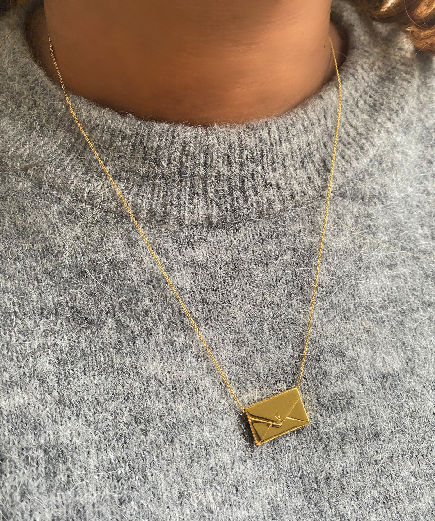 Model wearing gold engraved reversible envelope necklace with CZ crystalModel wearing gold engraved reversible envelope necklace with CZ crystal