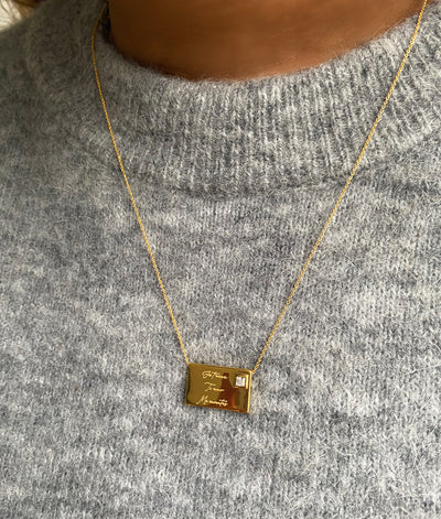 Model wearing gold engraved reversible envelope necklace with CZ crystalModel wearing gold engraved reversible envelope necklace with CZ crystal