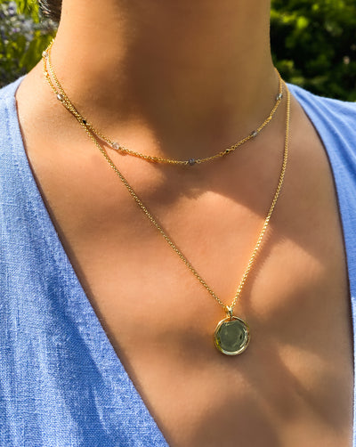 Model wearing gold plain coin pendant necklace and labradorite beaded choker 