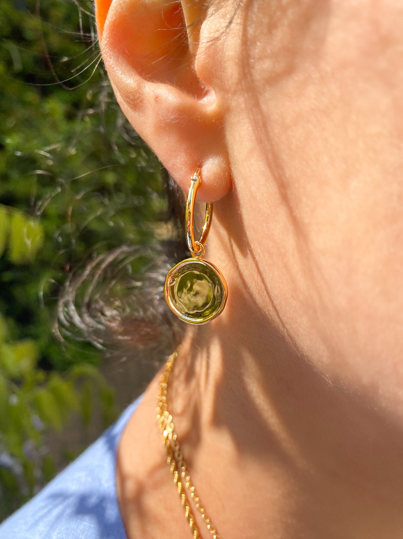 Model wearing simple gold plated sterling silver coin hoop earrings
