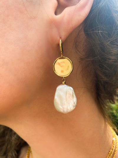Model wearing gold coin and freshwater pearl drop earrings