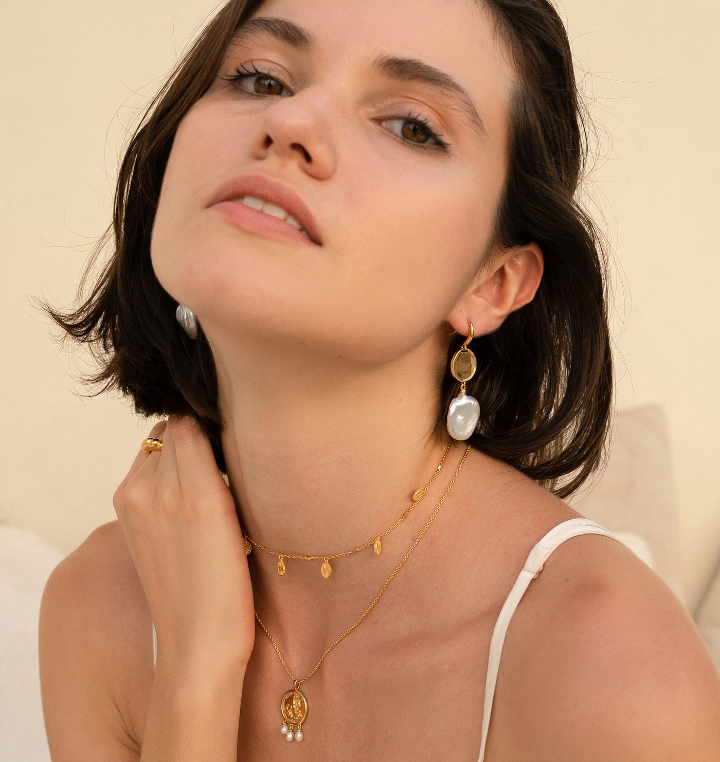 Model wearing gold engraved horse coin pendant necklace with hanging freshwater pearls with coin choker with CZ crystals and freshwater pearl and coin drop earrings
