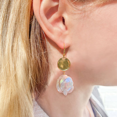 Model wearing gold coin and freshwater pearl drop earrings