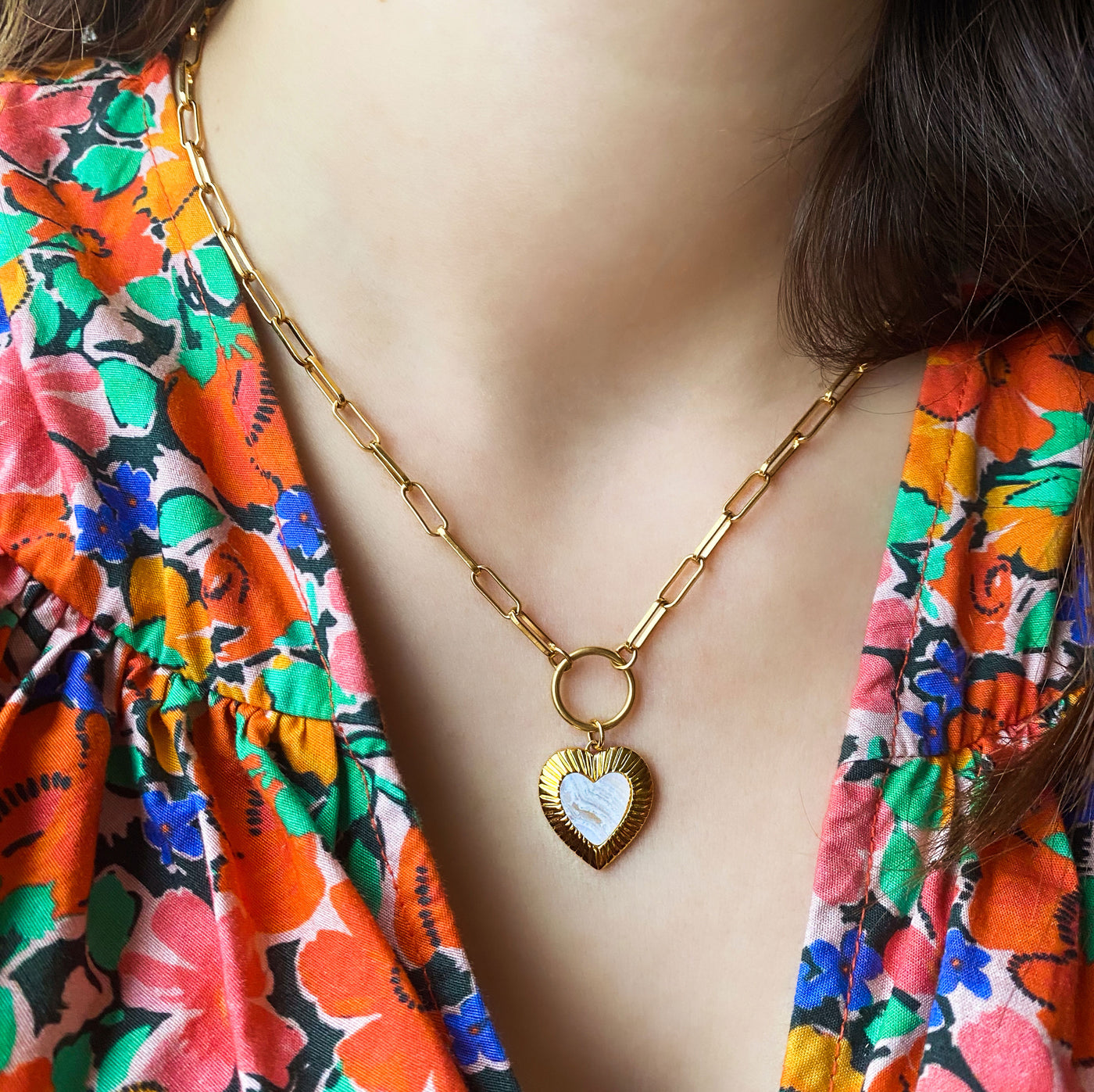 Model wearing chunky chain necklace with blue lace agate heart charm
