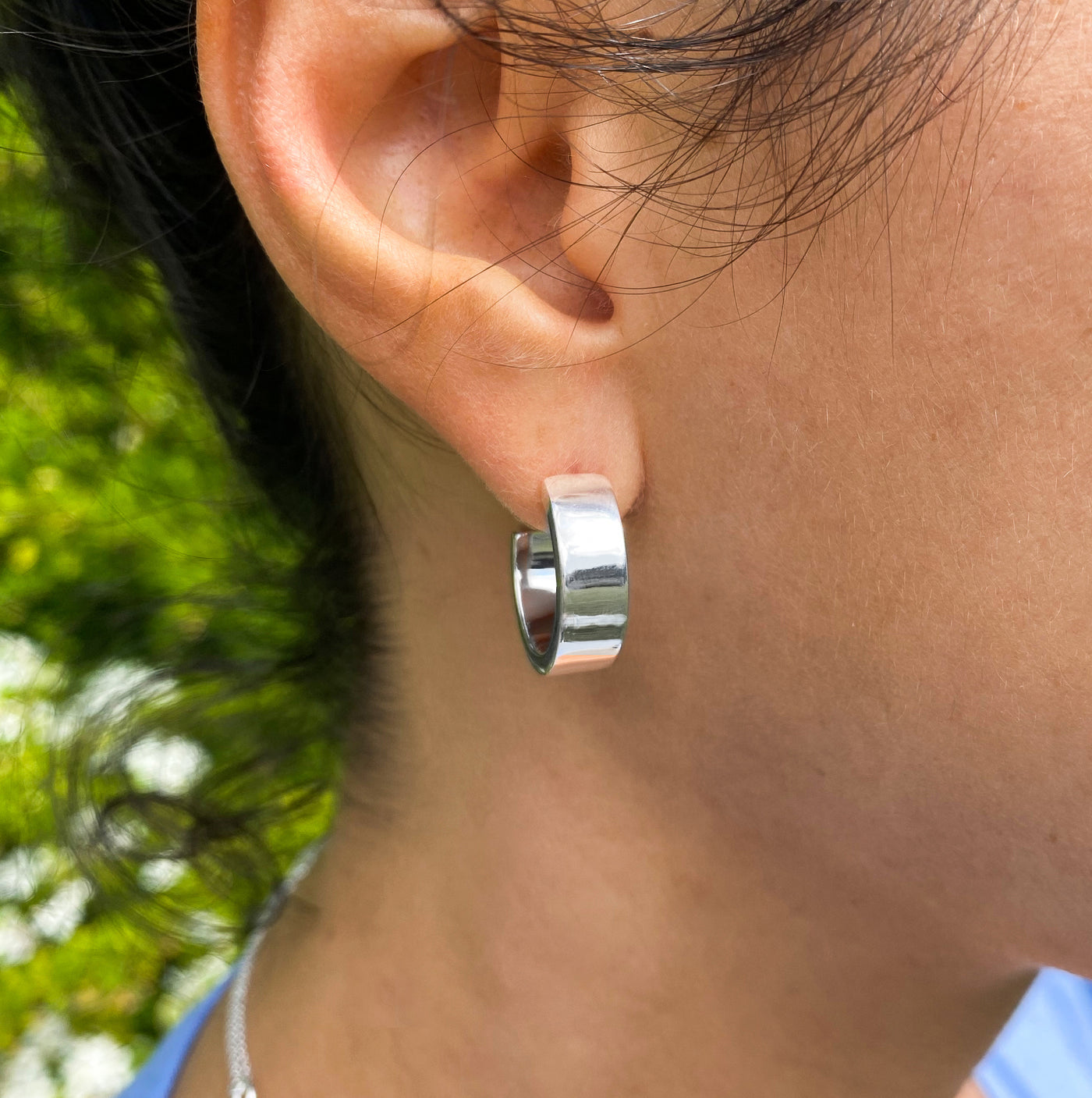 Model wearing chunky silver minimal hoop earrings
