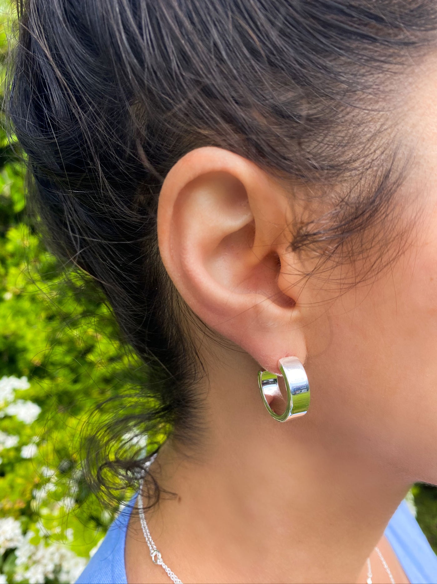 Model wearing chunky silver minimal hoop earrings
