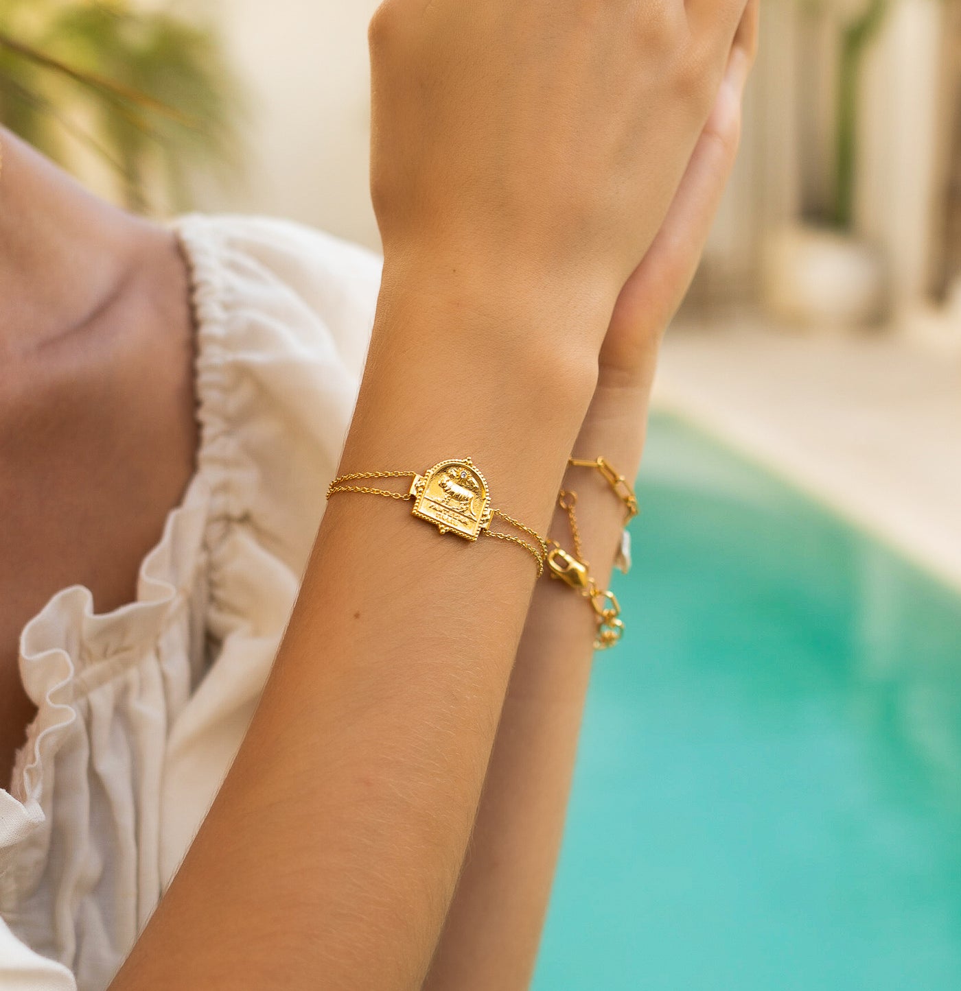 Model wearing gold plated sterling silver double chain bracelet featuring engraved tiger charm