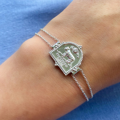 Model wearing sterling silver double chain bracelet featuring engraved tiger charm