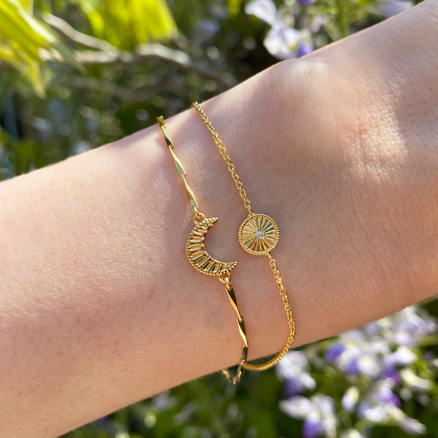 Model wearing gold plated sterling silver engraved set of 2 delicate sun and moon bracelets with CZ crystals