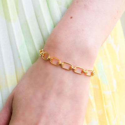 Model wearing gold plated sterling silver criss-cross link chunky chain bracelet