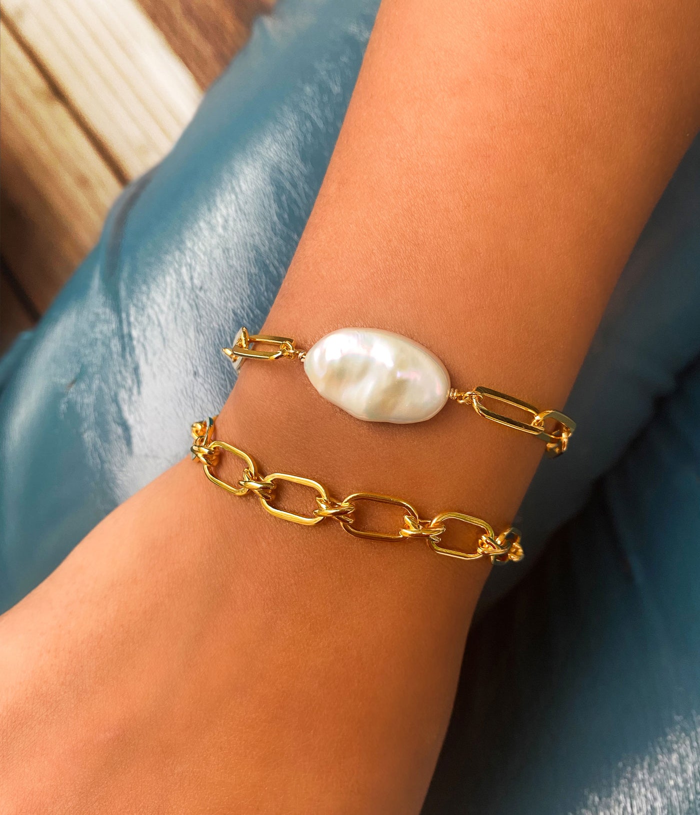 Model wearing gold plated sterling silver criss-cross link chunky chain bracelet with statement freshwater pearl bracelet 