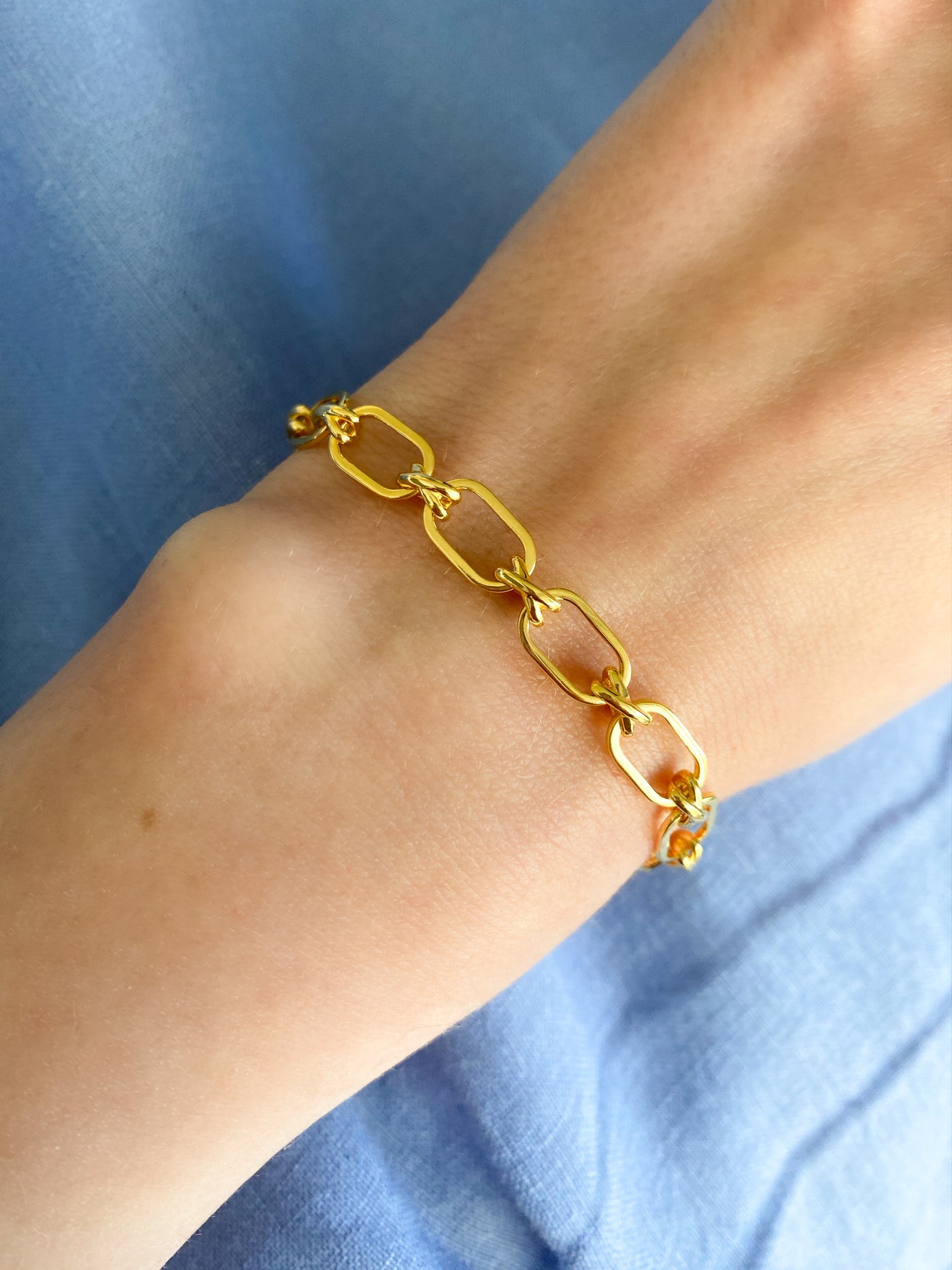 Model wearing gold plated sterling silver criss-cross link chunky chain bracelet