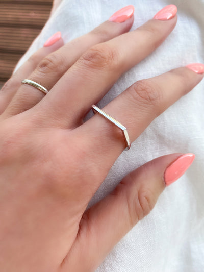 Model wearing sterling silver horseshoe shaped minimal plain ring and other ring band