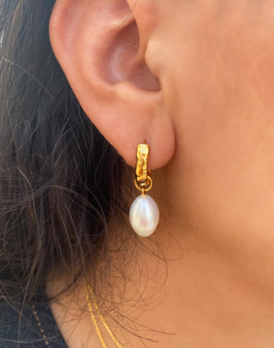 Model wearing bridal gold plated sterling silver textured hoop drop earrings featuring freshwater pearls