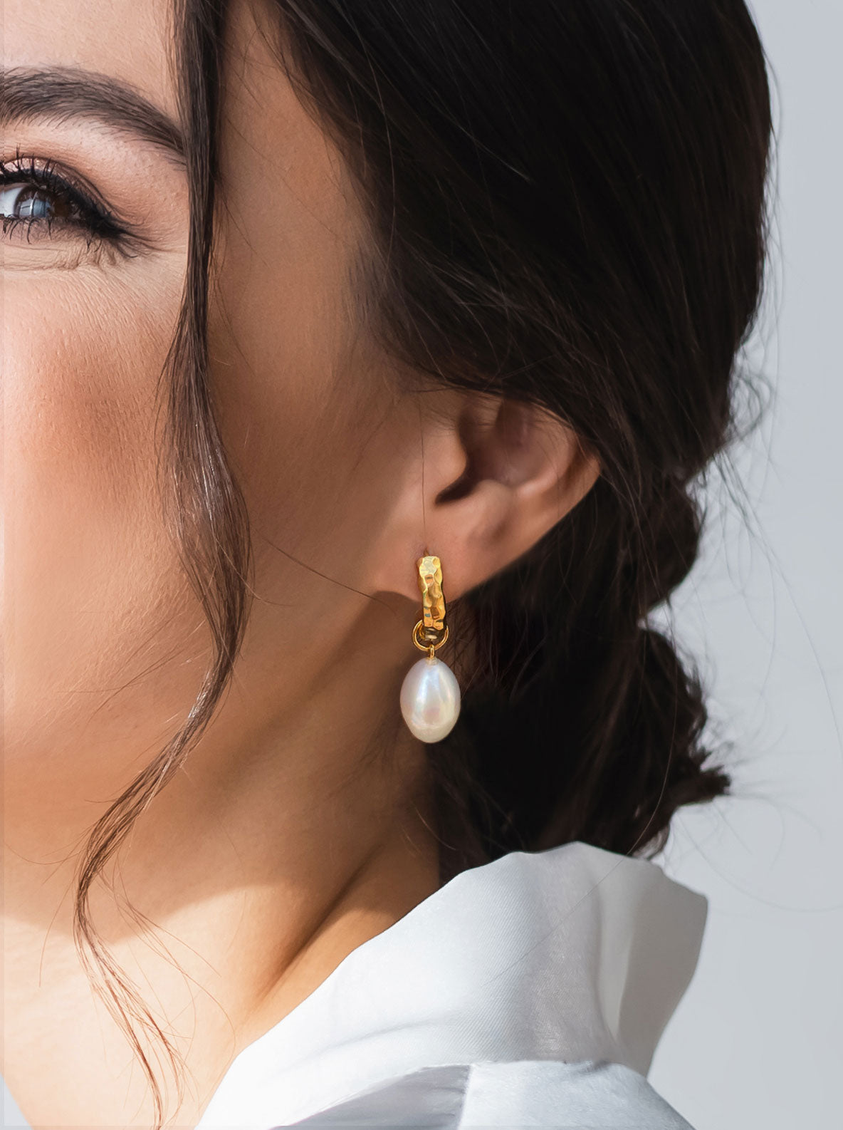 Model wearing bridal gold plated sterling silver textured hoop drop earrings featuring freshwater pearls