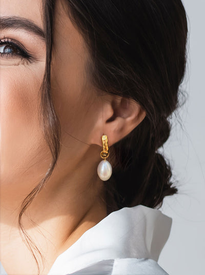 Model wearing bridal gold plated sterling silver textured hoop drop earrings featuring freshwater pearls