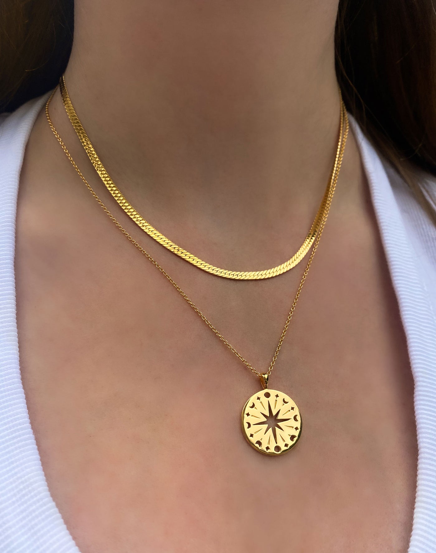 Model wearing gold filigree moon and star coin pendant with gold snake chain