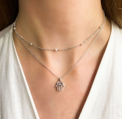 Model wearing sterling silver hamsa hand necklace with cz crystal with pearl choker