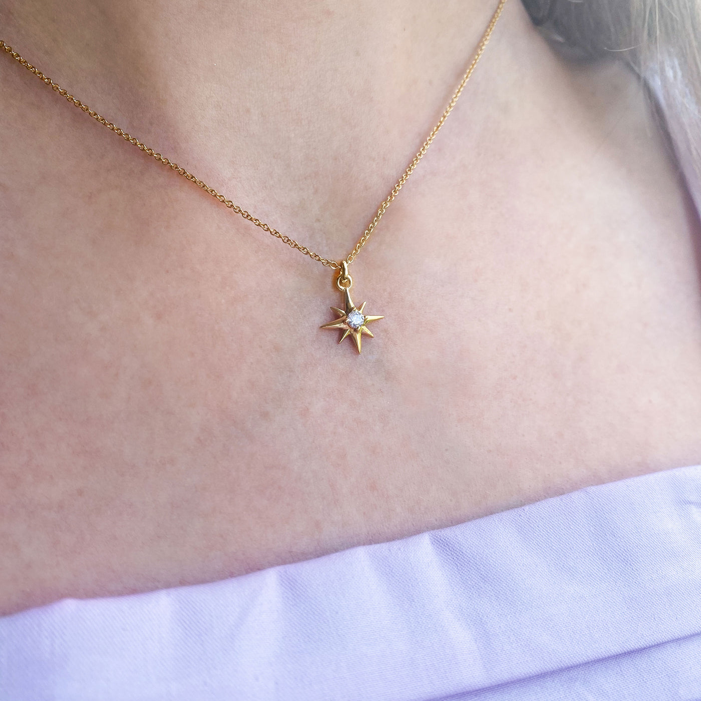 Model Wearing dainty 18kt gold plated sterling silver star necklace with a sparkling CZ crystal