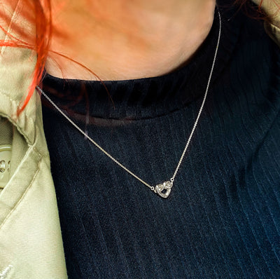 Model wearing sterling silver heart knot necklace