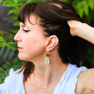 Model wearing gold rope necklace with coin and pearl earrings 