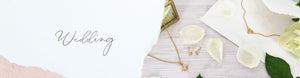 Wedding jewellery flatlay with gold heart knot bridesmaid necklace, crystal star necklace and crystal star stud earrings