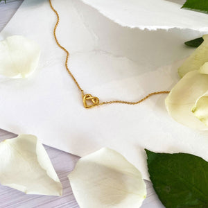 Wedding jewellery flatlay with gold heart knot necklace gift for bridesmaids
