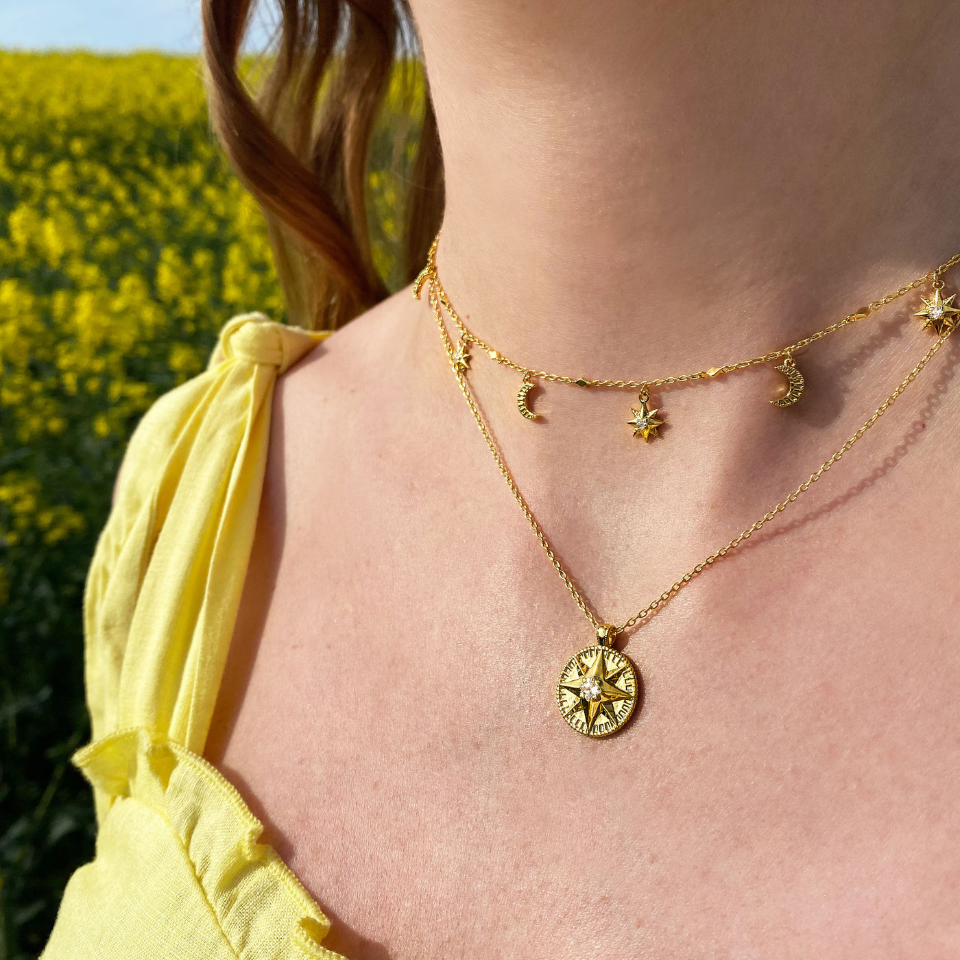 Model wearing gold 3D star coin necklace, moon necklace and matching choker with CZ crystals