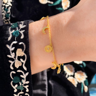 Model wearing gold plated sterling Silver moon and star charm bracelet with CZ crystals