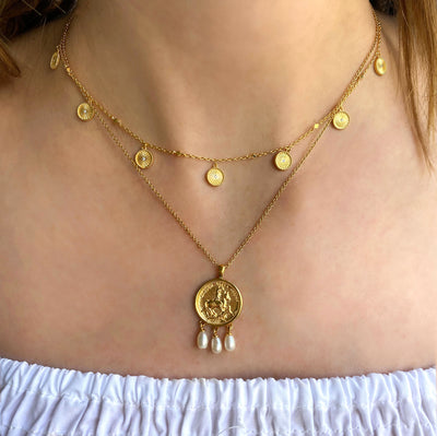 Model wearing gold engraved horse coin pendant necklace with hanging freshwater pearls  with coin choker with CZ crystals and freshwater pearl and coin drop earrings