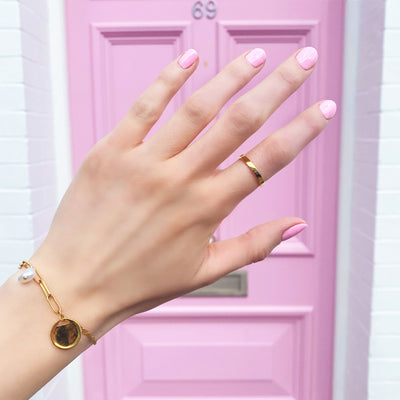 Model wearing simple gold plated sterling silver plain, minimal ring band with coin and freshwater pearl chain bracelet