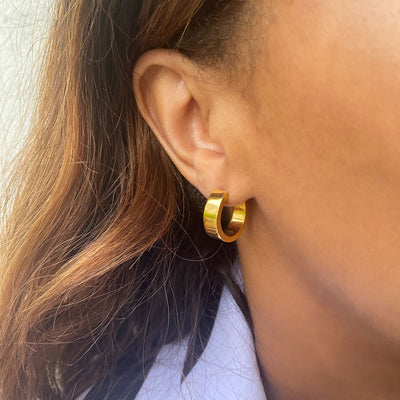 Model wearing gold plated sterling silver chunky gold minimal hoop earrings