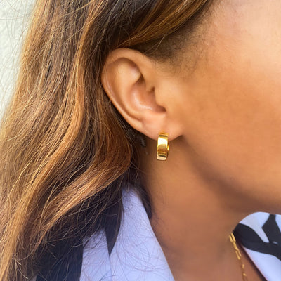 Model wearing gold plated sterling silver chunky gold minimal hoop earrings